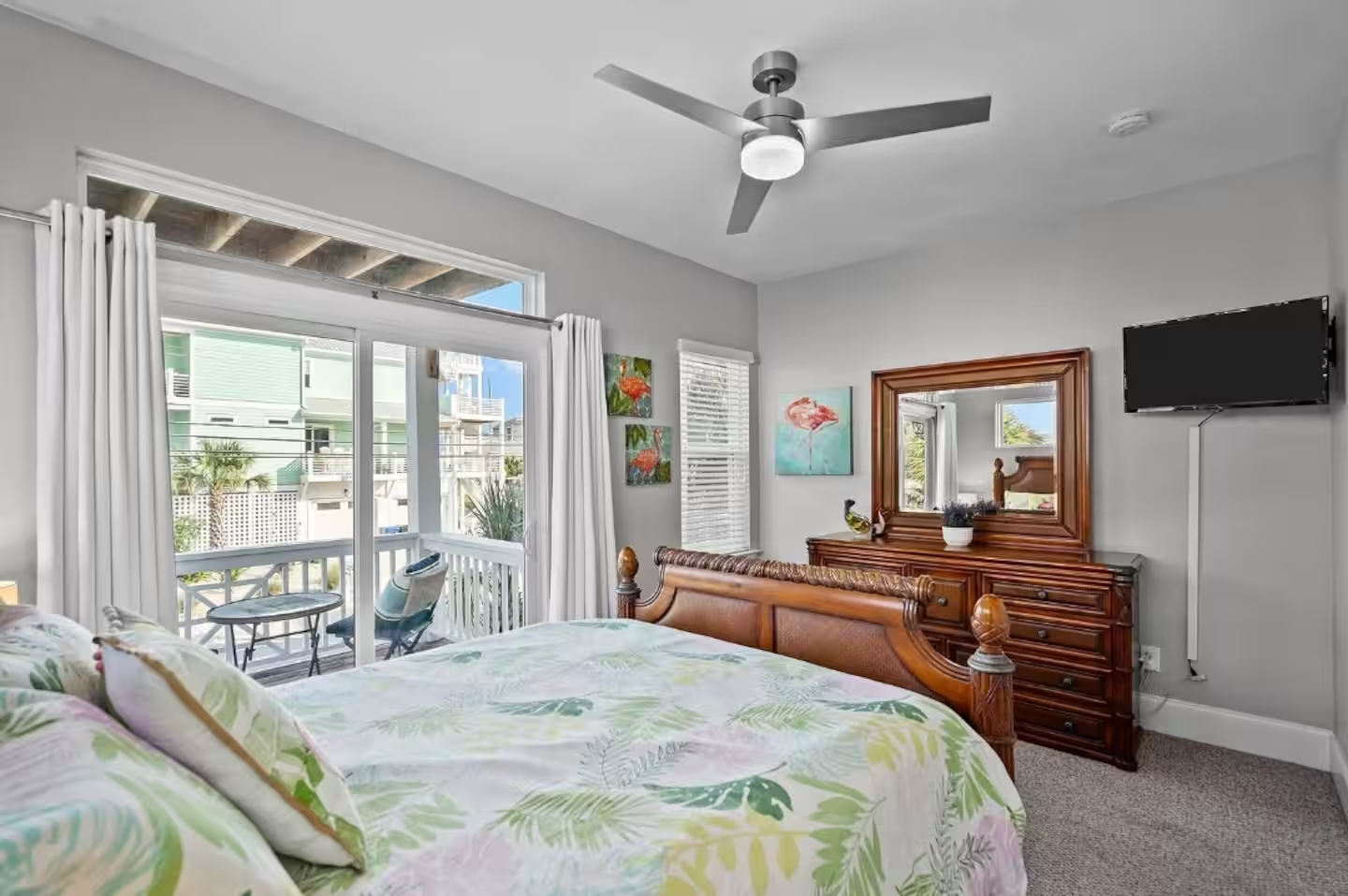 Bright bedroom at Shore Thing Y’all with a queen bed, television, and private balcony
